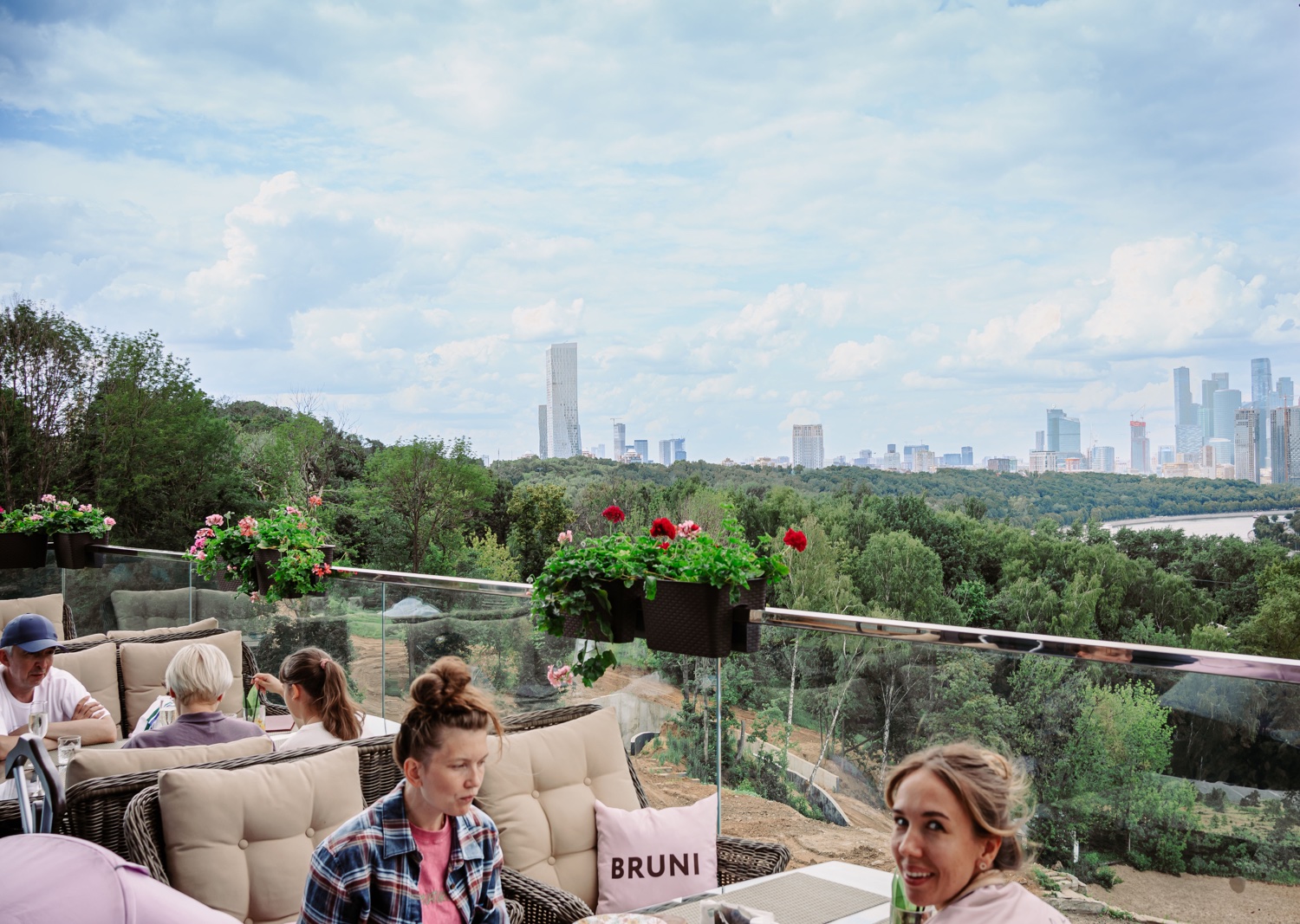 Гости веранды на фоне панорамы Москвы и парка